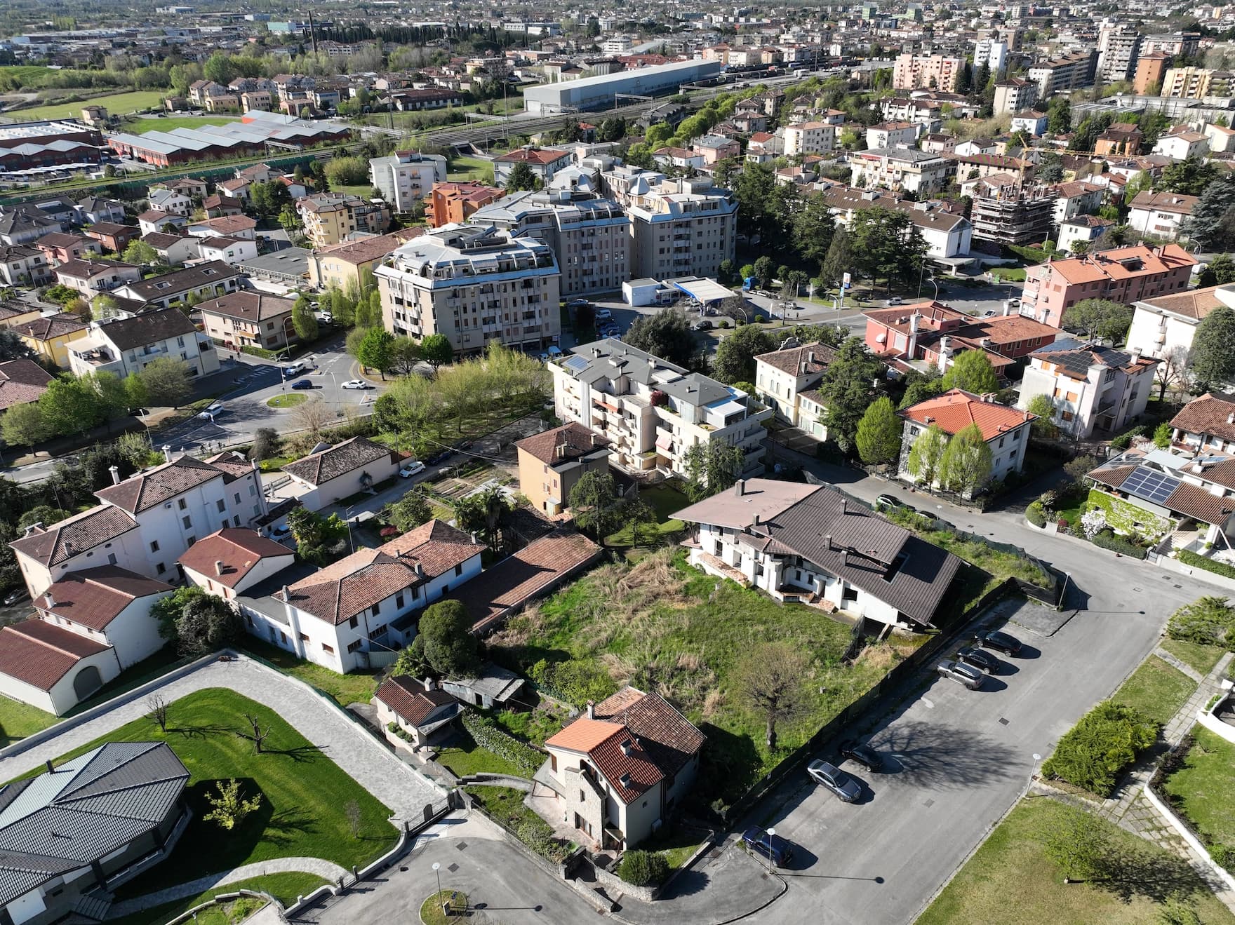 Vista aerea di area urbana residenziale con lotto edificabile vuoto al centro – fotografia base